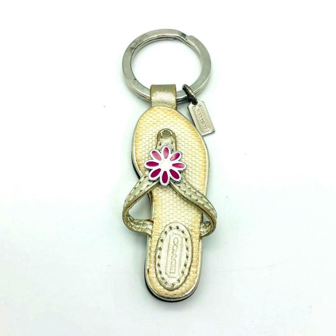COACH sandal-shaped charm keychain with a pink flower accent and a small metal Coach tag on a white background.