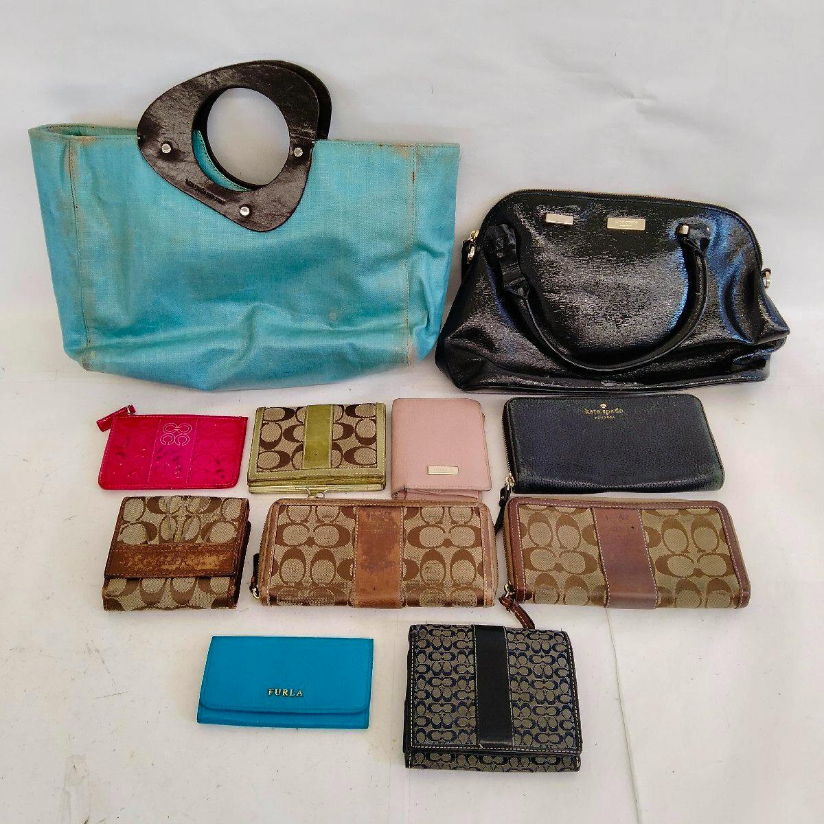 Eleven bags and wallets displayed on a white surface, including a turquoise tote, a black patent bag, and several patterned wallets.