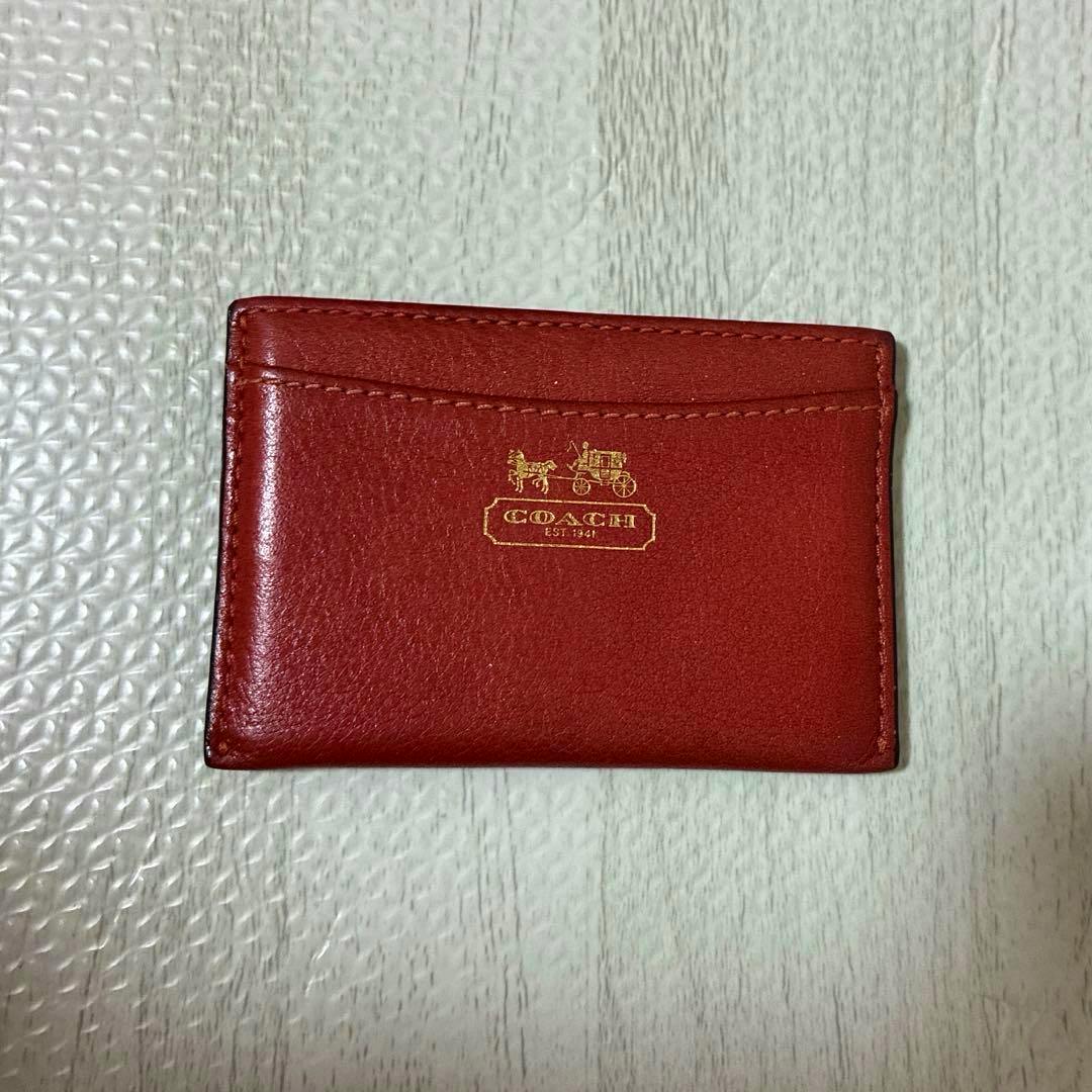Front view of COACH genuine leather card holder (brown) showing the gold Coach logo and a front card pocket.