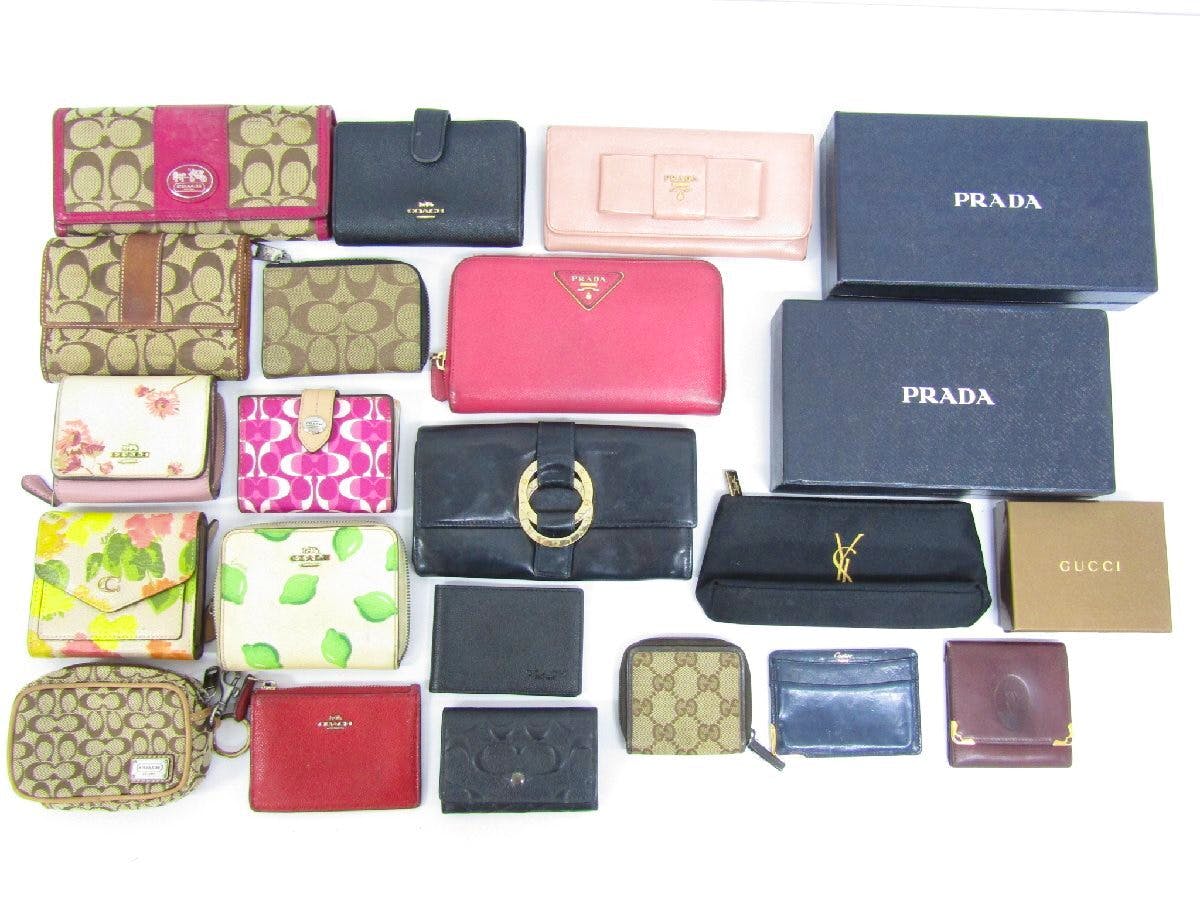 Assorted wallets and small leather goods from multiple brands arranged on a white background.
