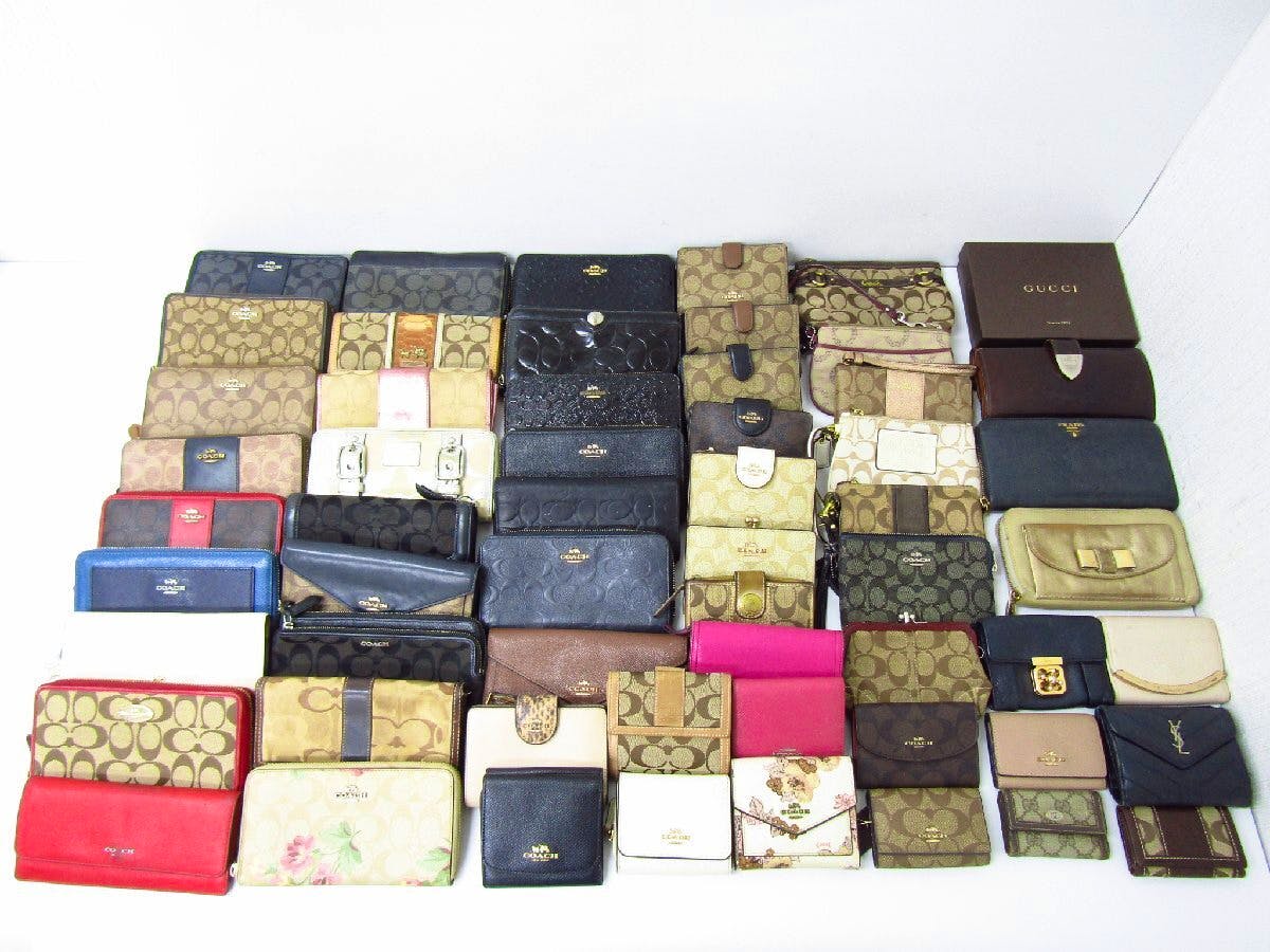 Multiple wallets and key cases arranged together on a white surface as a bulk lot.