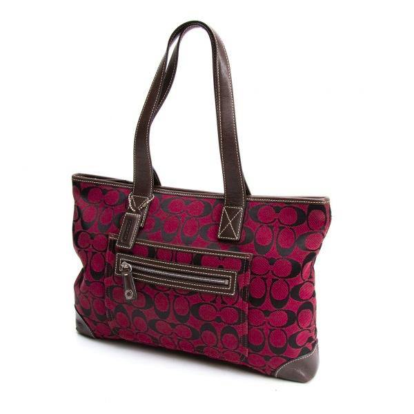 Red-brown COACH signature canvas handbag with a front zip pocket and brown leather straps.