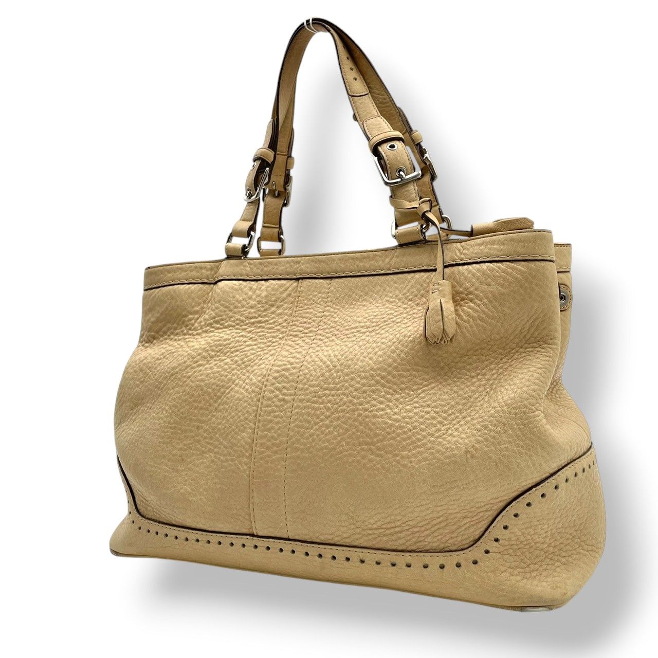 Beige Coach Hamptons carryall leather tote bag with double shoulder straps on a white background.