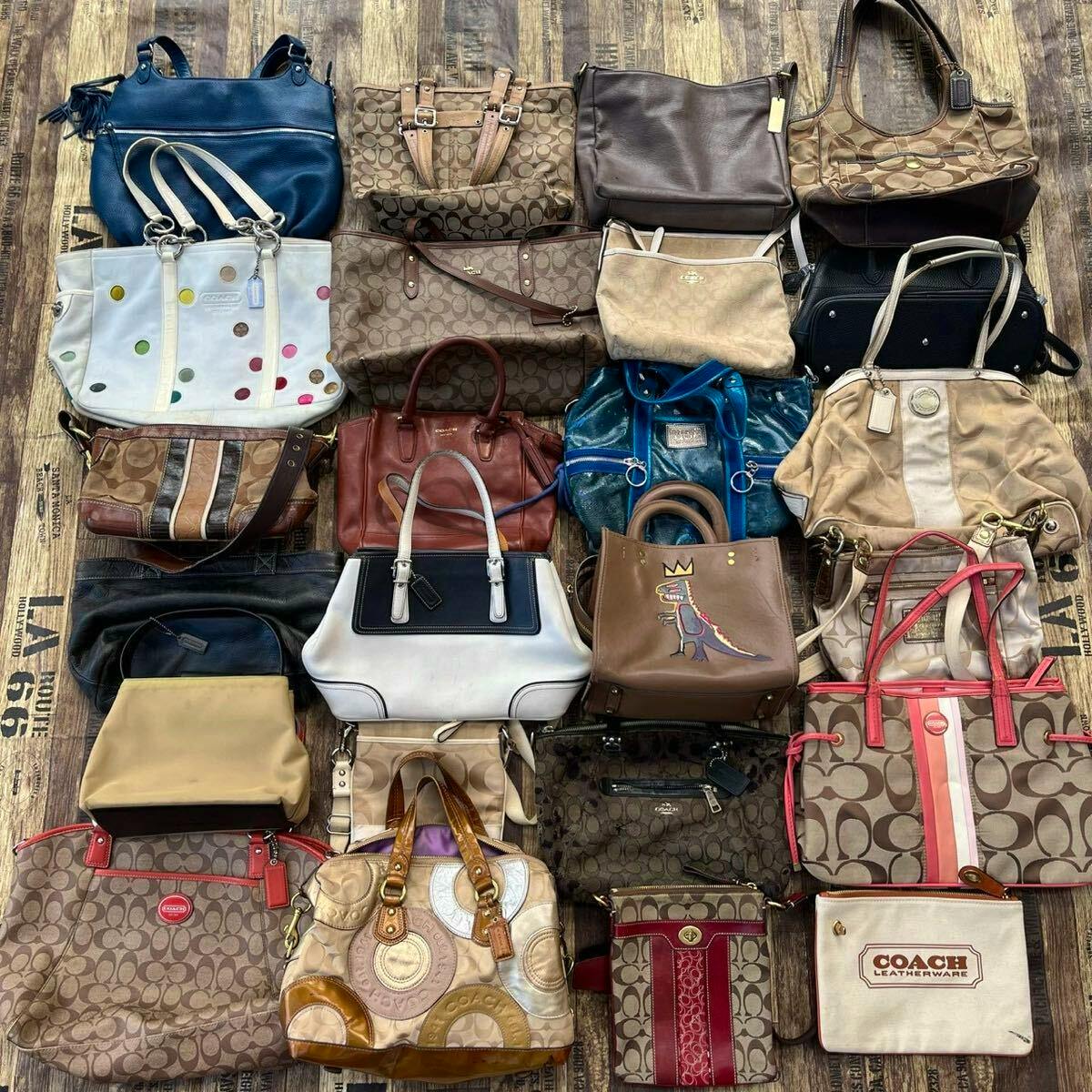 Overhead photo showing many Coach and other brand handbags and shoulder bags arranged on a wooden floor as a bulk 25-piece bag set.