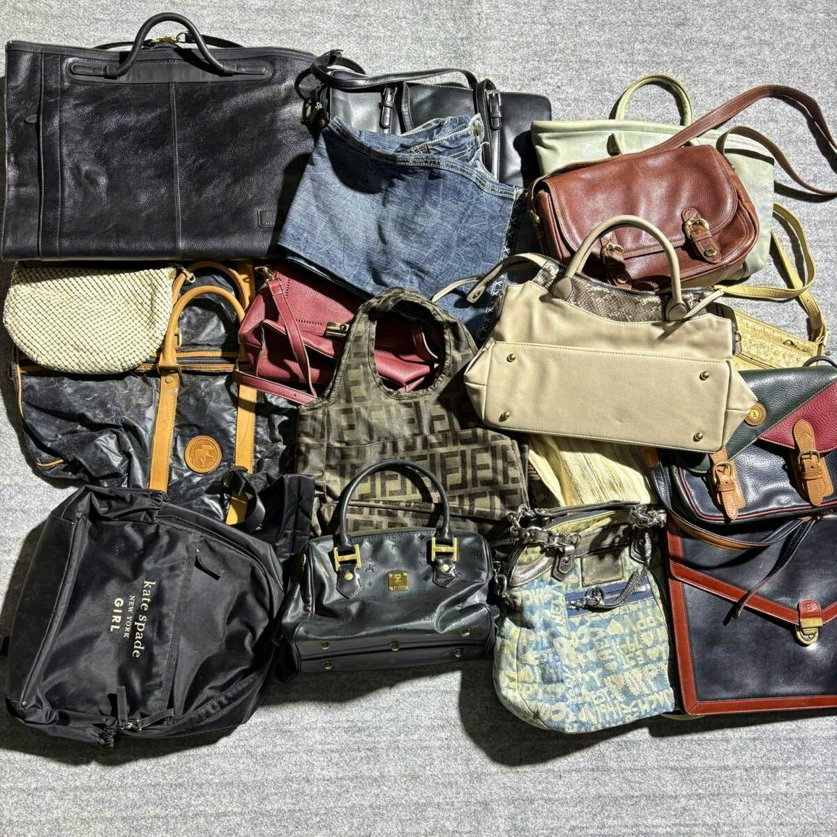 Multiple handbags and bags from a mixed-brand lot (e.g., Coach, Hunting World, MCM) laid out on a gray surface.