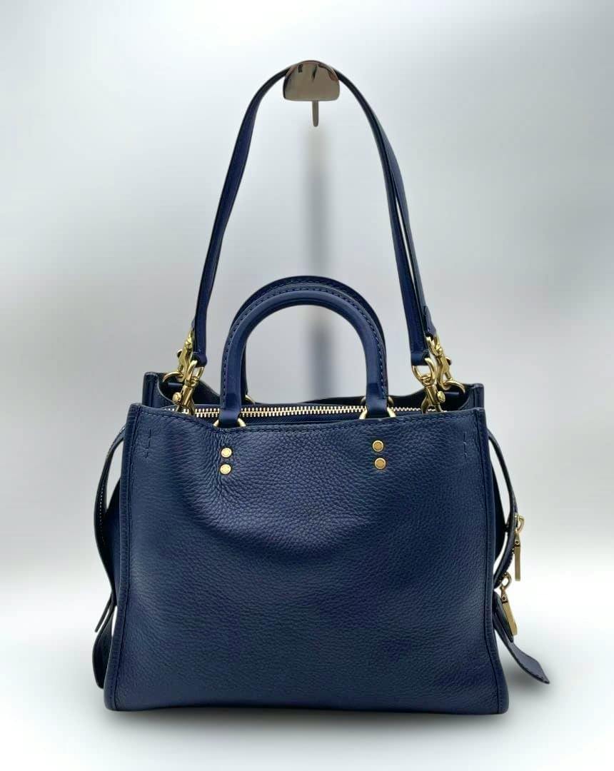 Front view of a navy Coach leather 2WAY bag (38124) with top handles, a long shoulder strap, and gold-tone hardware.