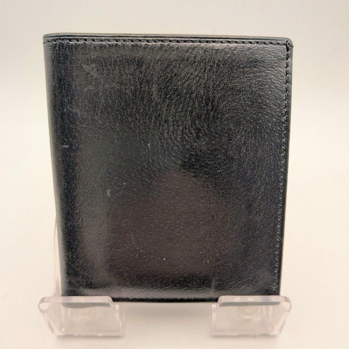 Black leather card case (pass case) standing on a clear plastic display stand against a white background.