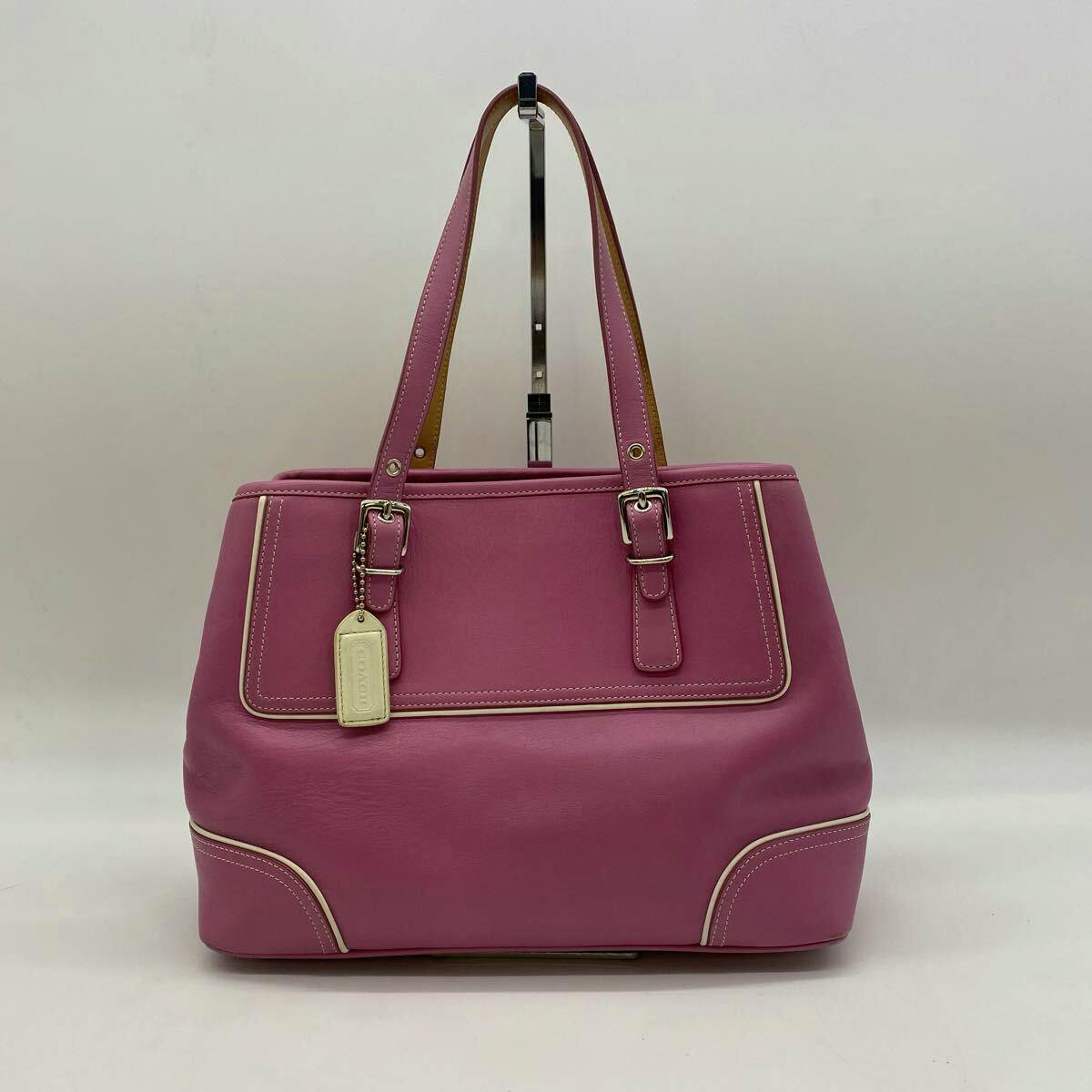 Front view of the pink Coach cow leather tote handbag with two top handles and a hanging tag against a plain background.
