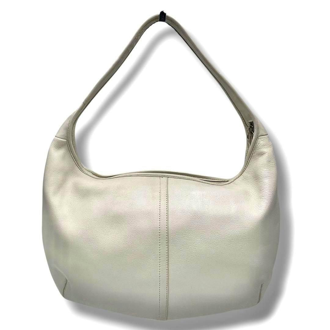 Front view of a light-colored Coach leather hobo shoulder bag with a single shoulder strap.