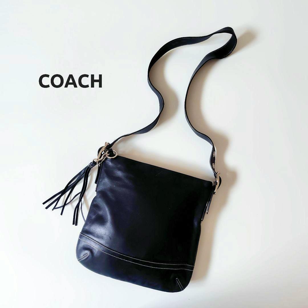 Black leather Coach shoulder bag with tassel shown on a white background.