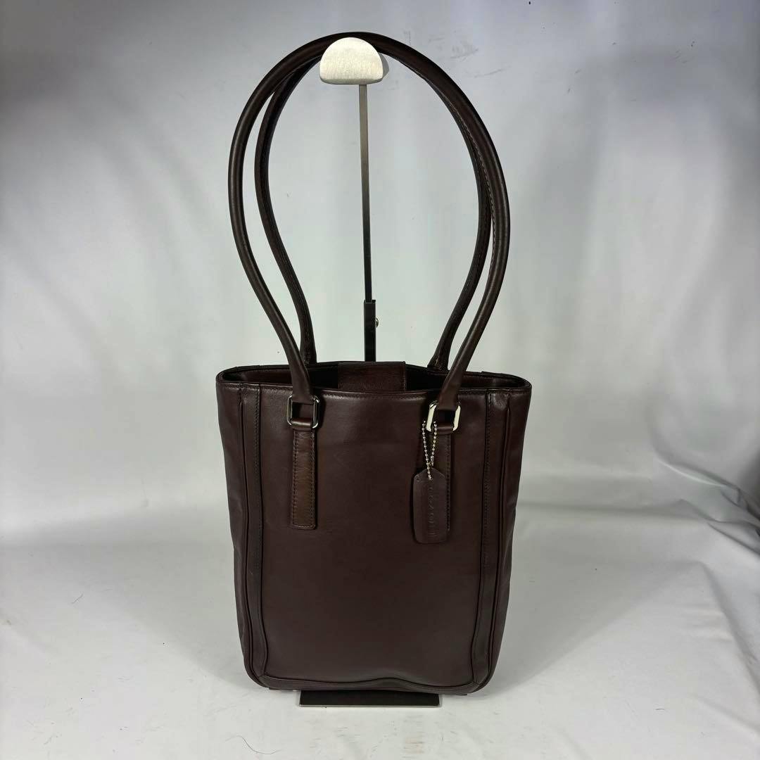 Dark brown leather shoulder tote bag with double handles and a hanging leather tag.