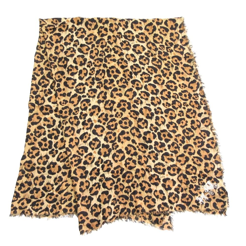 Leopard-print large scarf with fringed edges laid flat showing brown and black pattern.