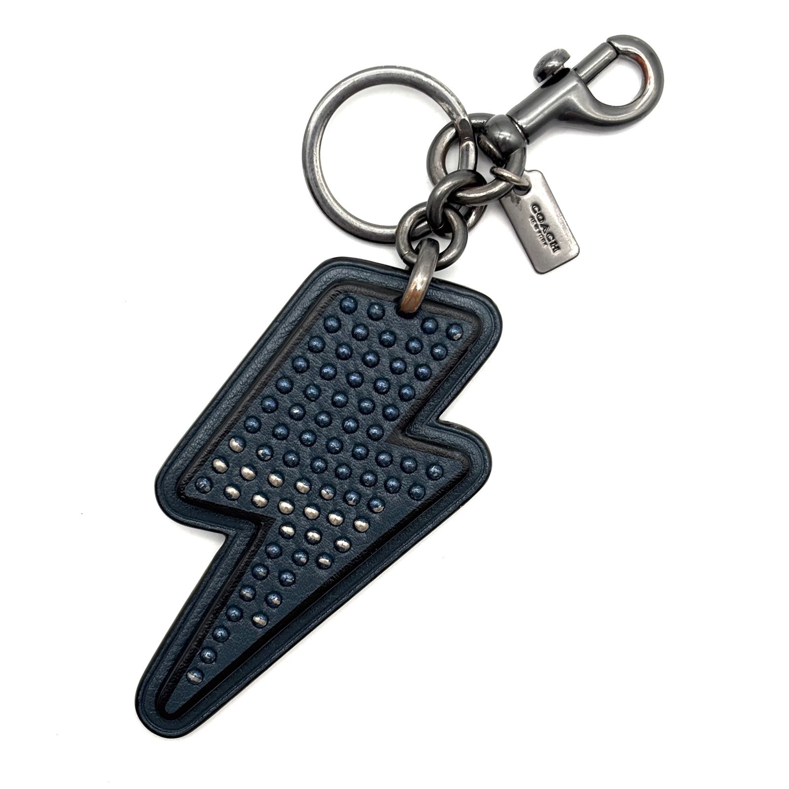 Navy leather lightning-bolt keychain with stud detailing, metal key ring, lobster clasp, and small Coach tag.