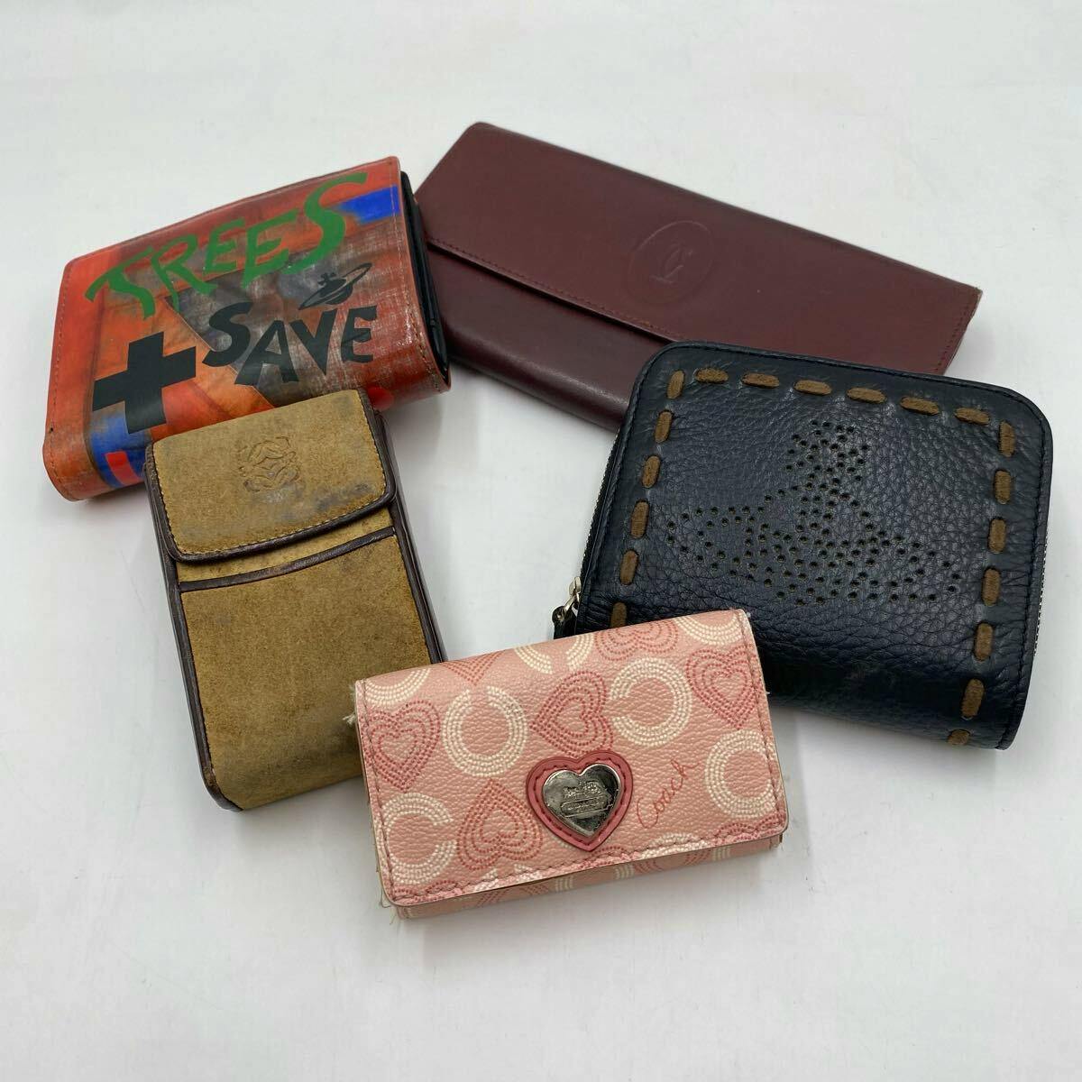 A set of five wallets and key cases arranged on a white background showing different designs and colors.