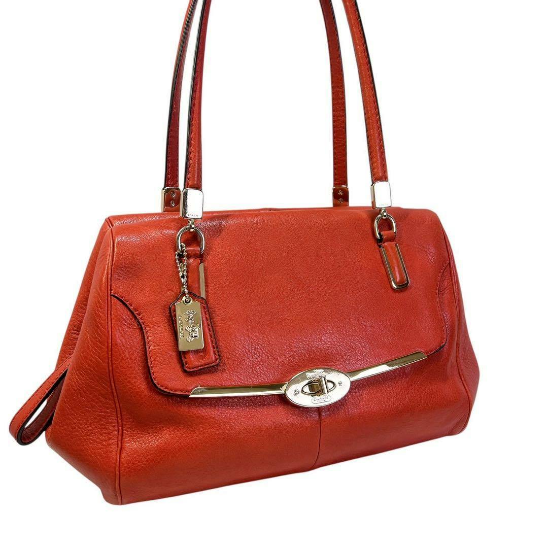 Three-quarter front view of the red Coach Madison turnlock cow leather shoulder bag with double straps and gold-tone hardware.