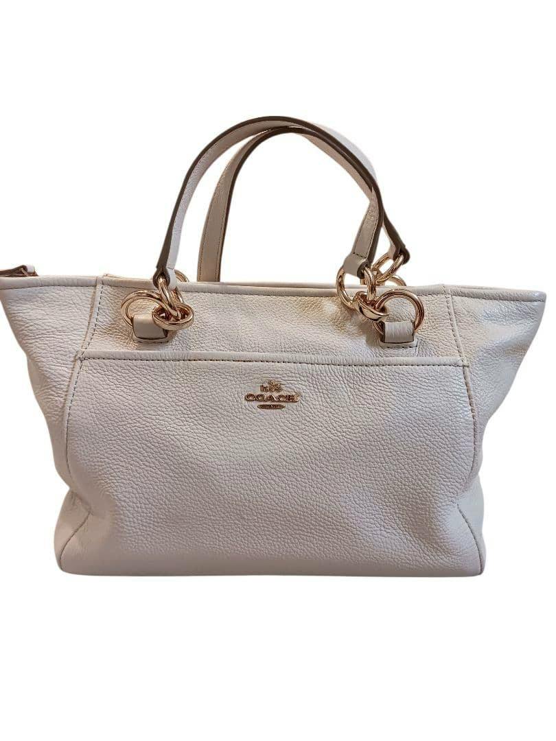 Front view of the COACH mini Ellis bag in light color with gold hardware and top handles.