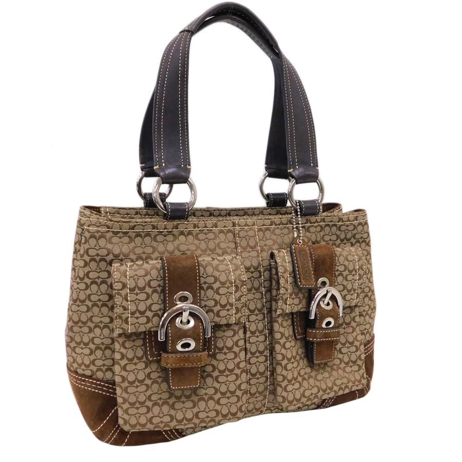 Brown Coach canvas and leather handbag with signature 'C' monogram, two leather shoulder straps, and front buckle pockets.