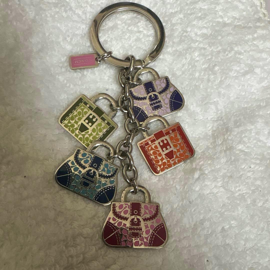 Front of multicolor COACH keychain showing five purse-shaped charms on a metal ring against a white background.