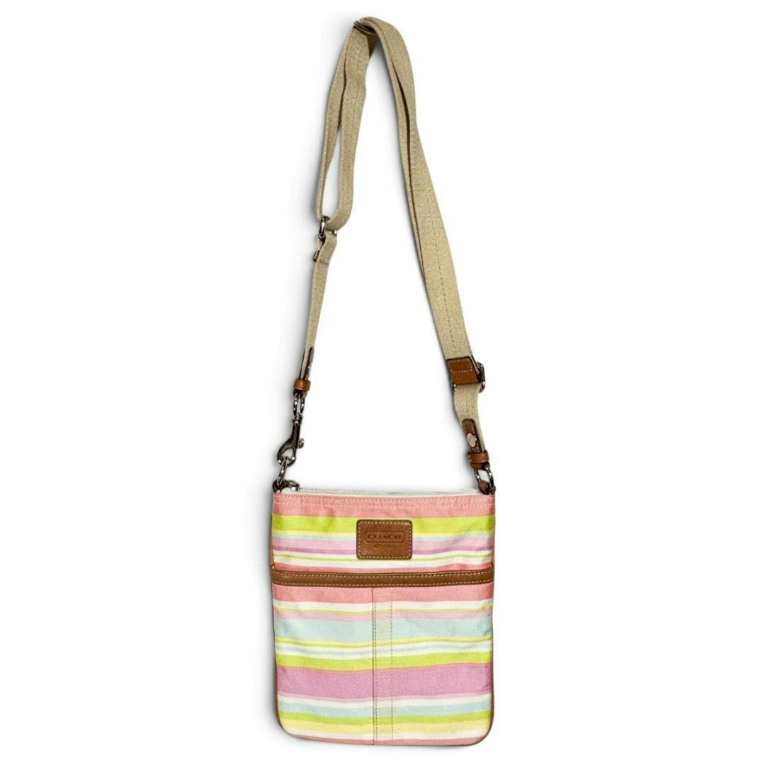 Front view of a Coach multicolor striped shoulder bag with leather trim and an adjustable beige canvas strap.