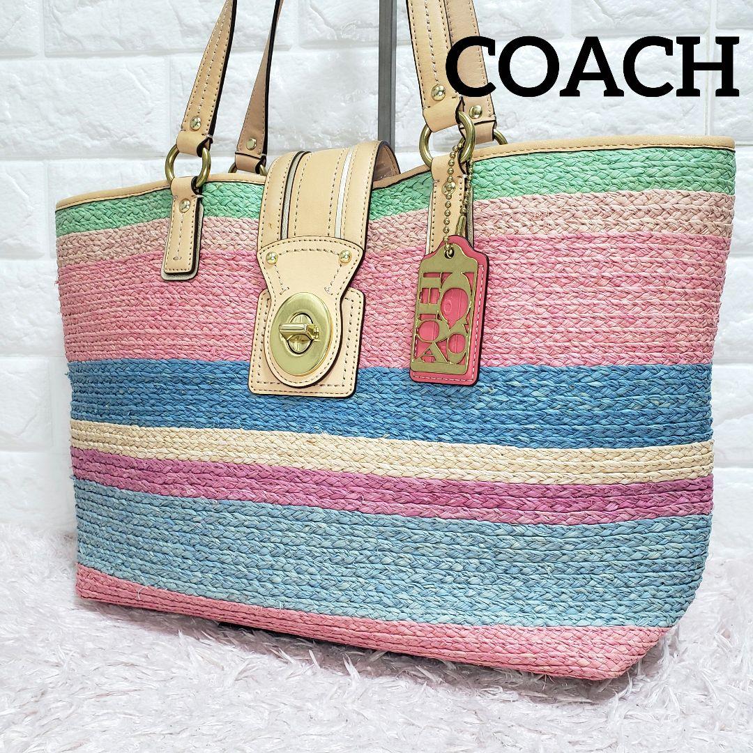 Multicolor striped woven Coach basket tote bag with leather handles, turn-lock flap, and hanging Coach tag.