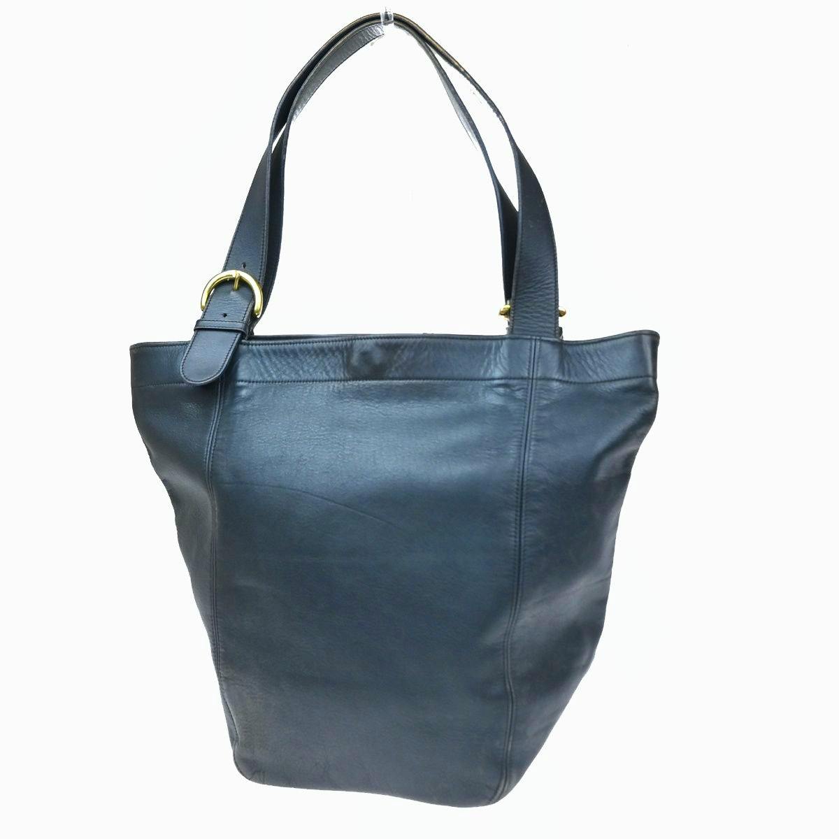 Front view of a navy Coach cow leather tote shoulder bag with buckled straps.