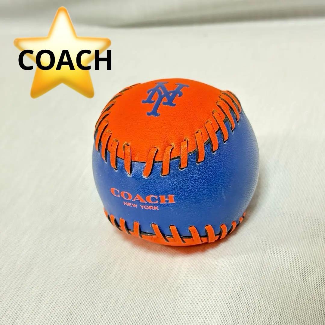 Blue-and-orange Coach Mets baseball showing stitched leather panels and the COACH NEW YORK logo.