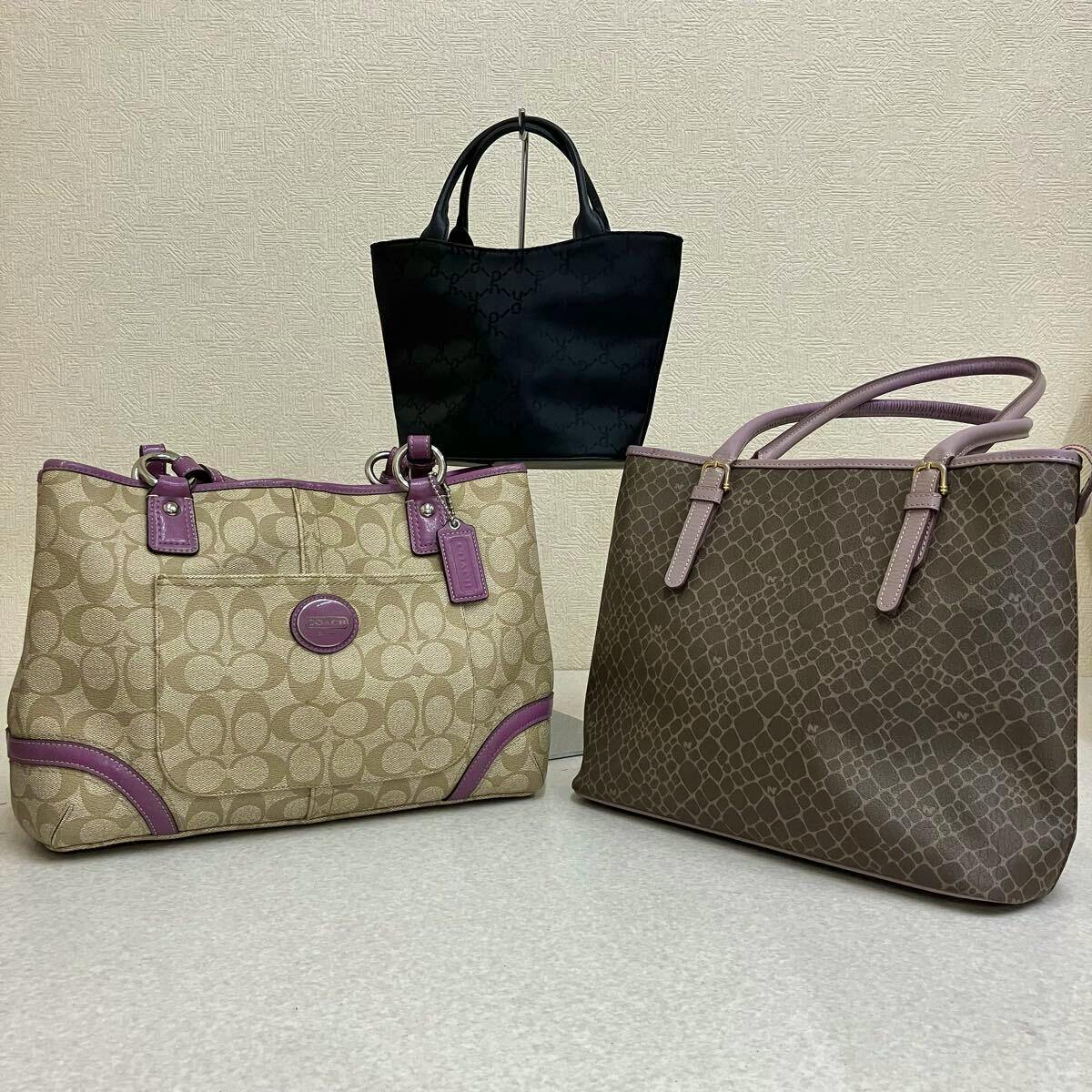 Three tote bags shown together: a beige monogram tote with purple trim at left, a brown patterned tote at right, and a small black tote in the back center.