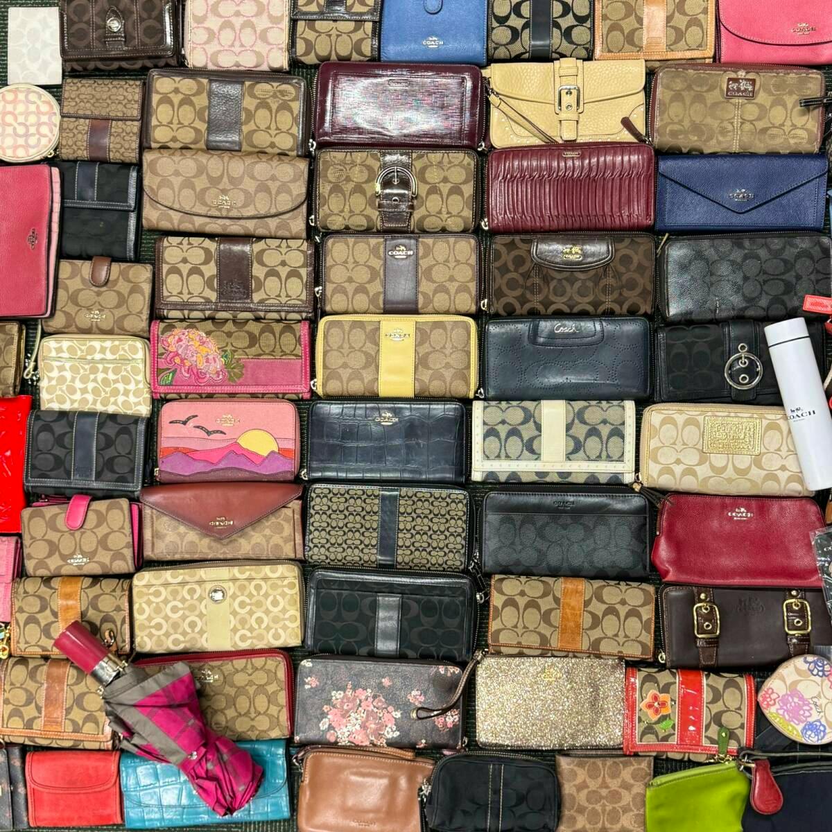 Top-down photo of many Coach wallets and small leather pouches arranged in a grid.