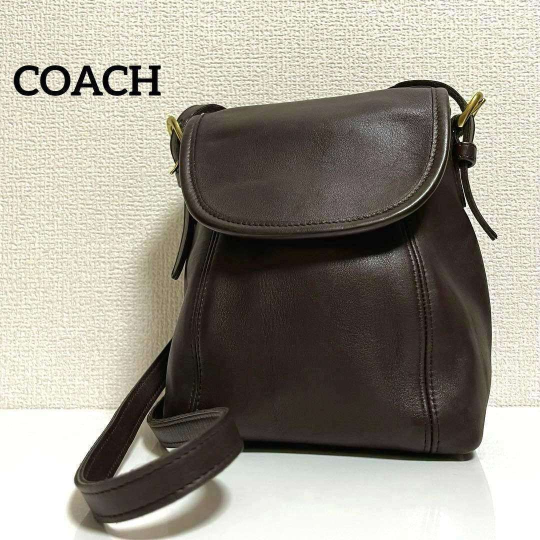 Brown leather COACH shoulder bag with a flap closure and strap photographed against a textured wall.