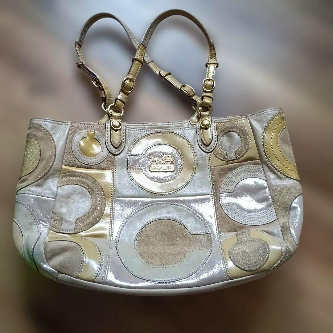 Beige and cream Coach patchwork tote bag with circular patch designs and double shoulder straps.