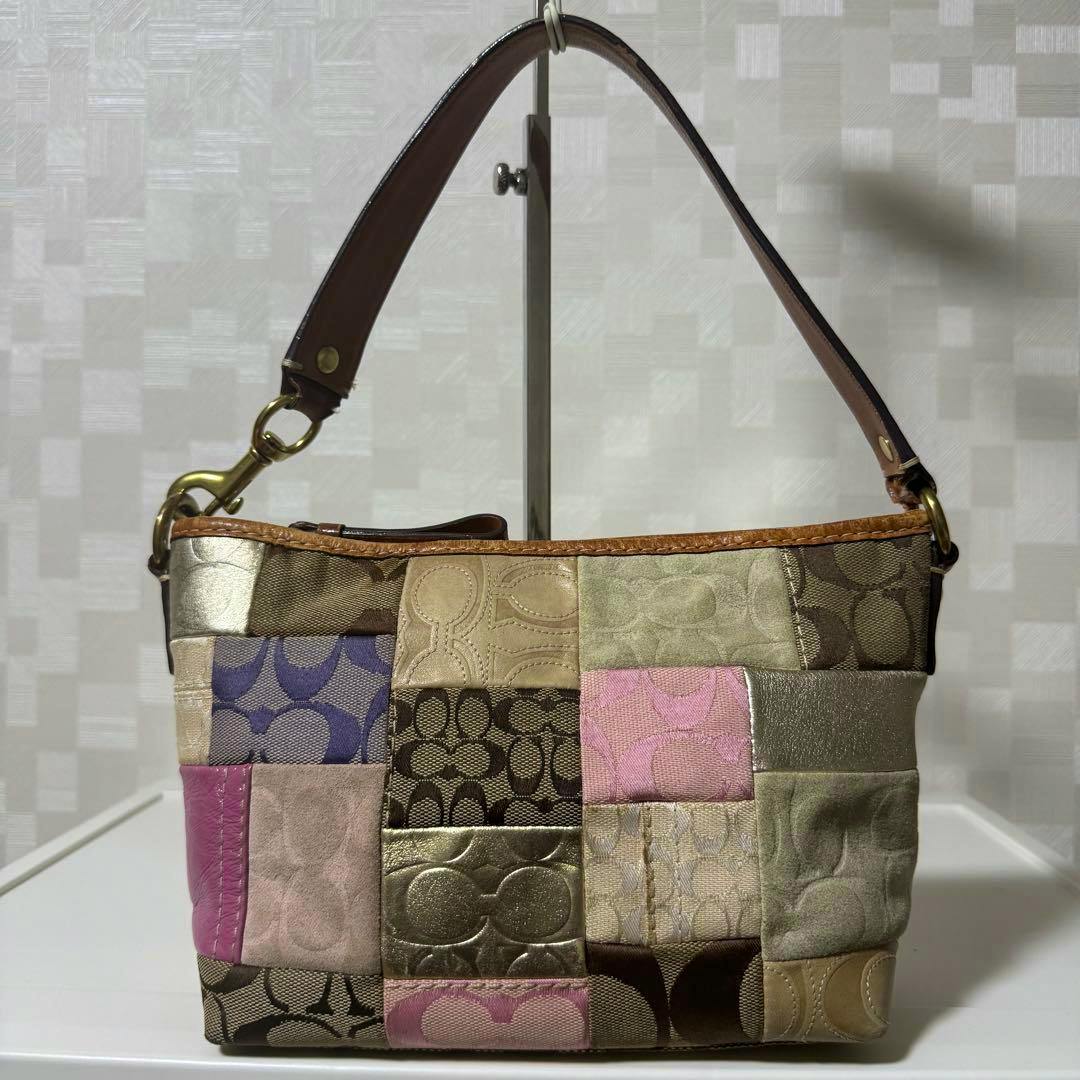 Front view of the COACH patchwork one-shoulder bag in pink and neutral tones with its single shoulder strap visible.