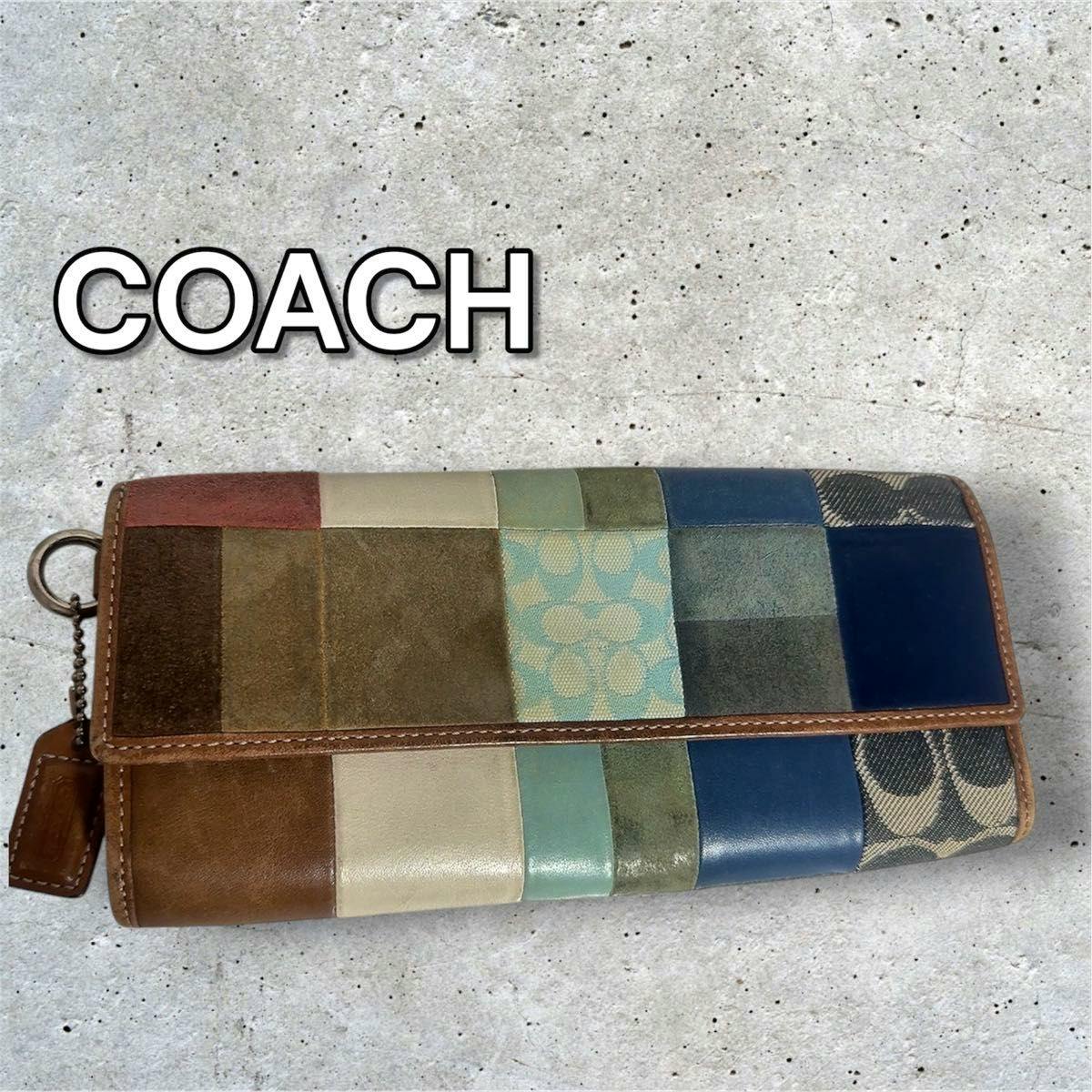 Closed multicolor patchwork Coach long flap wallet showing suede, leather, and signature fabric panels.