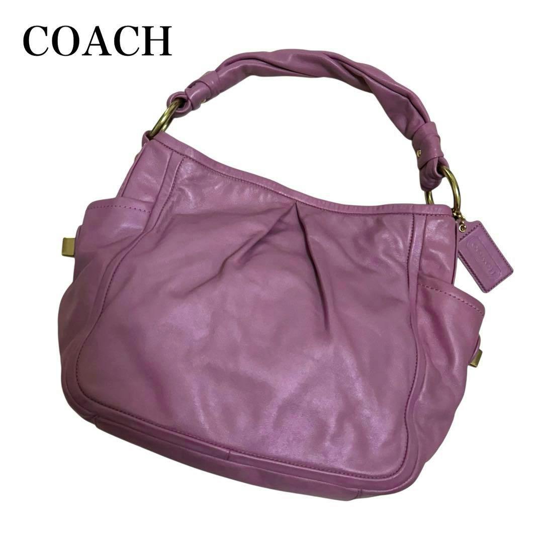 Pink leather Coach shoulder tote bag photographed against a white background showing the bag's handle and attached tag.