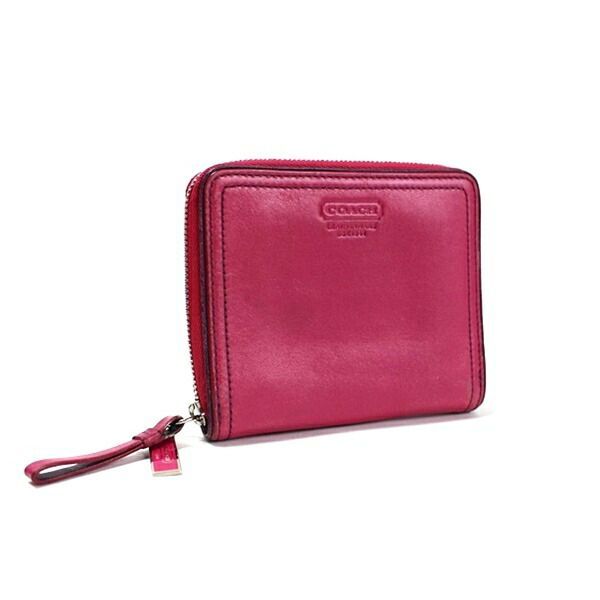 Pink Coach leather zip-around wallet shown at a slight angle with visible zipper pull.