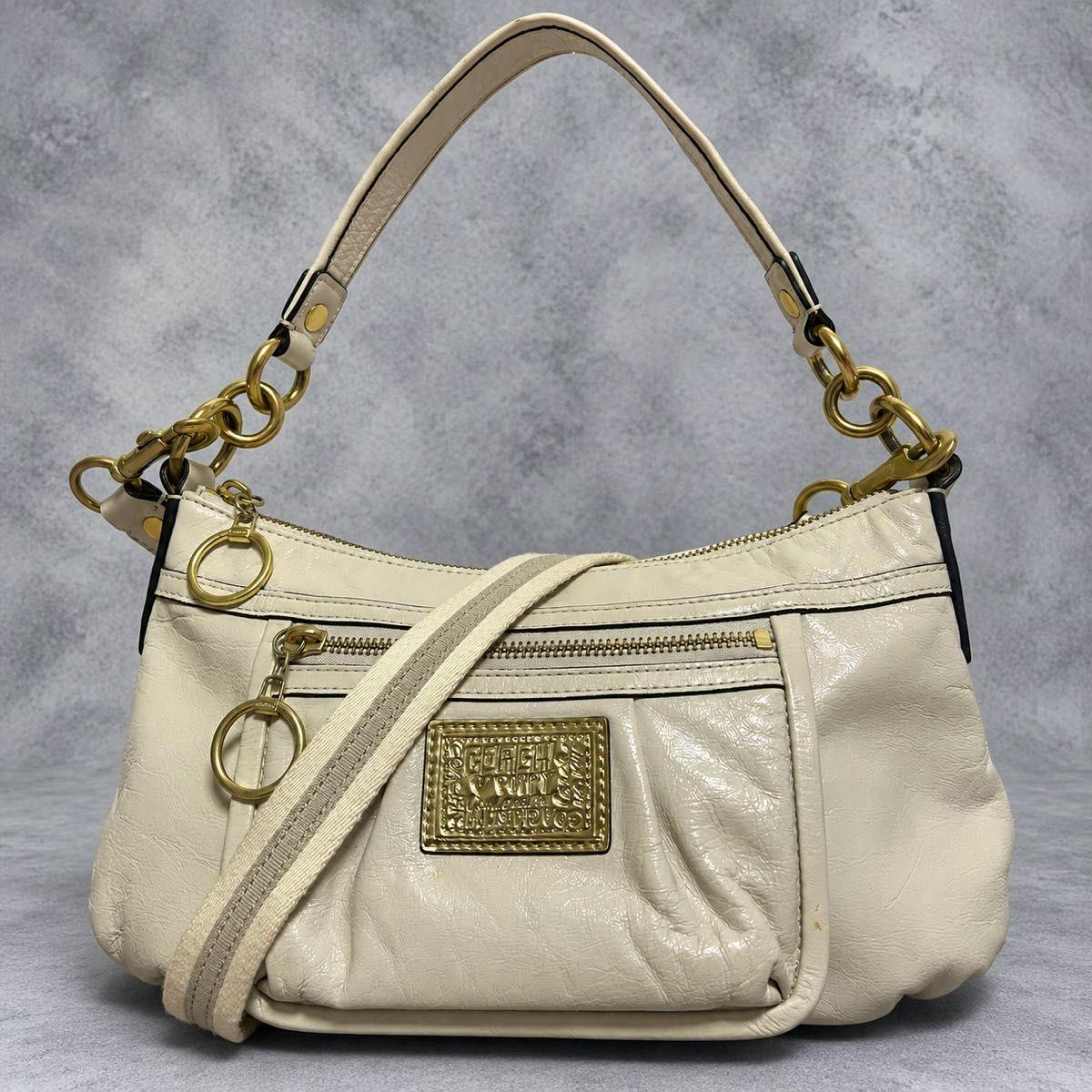 White Coach 2way POPPY shoulder bag with gold hardware, front zipper pocket, and logo plaque visible.