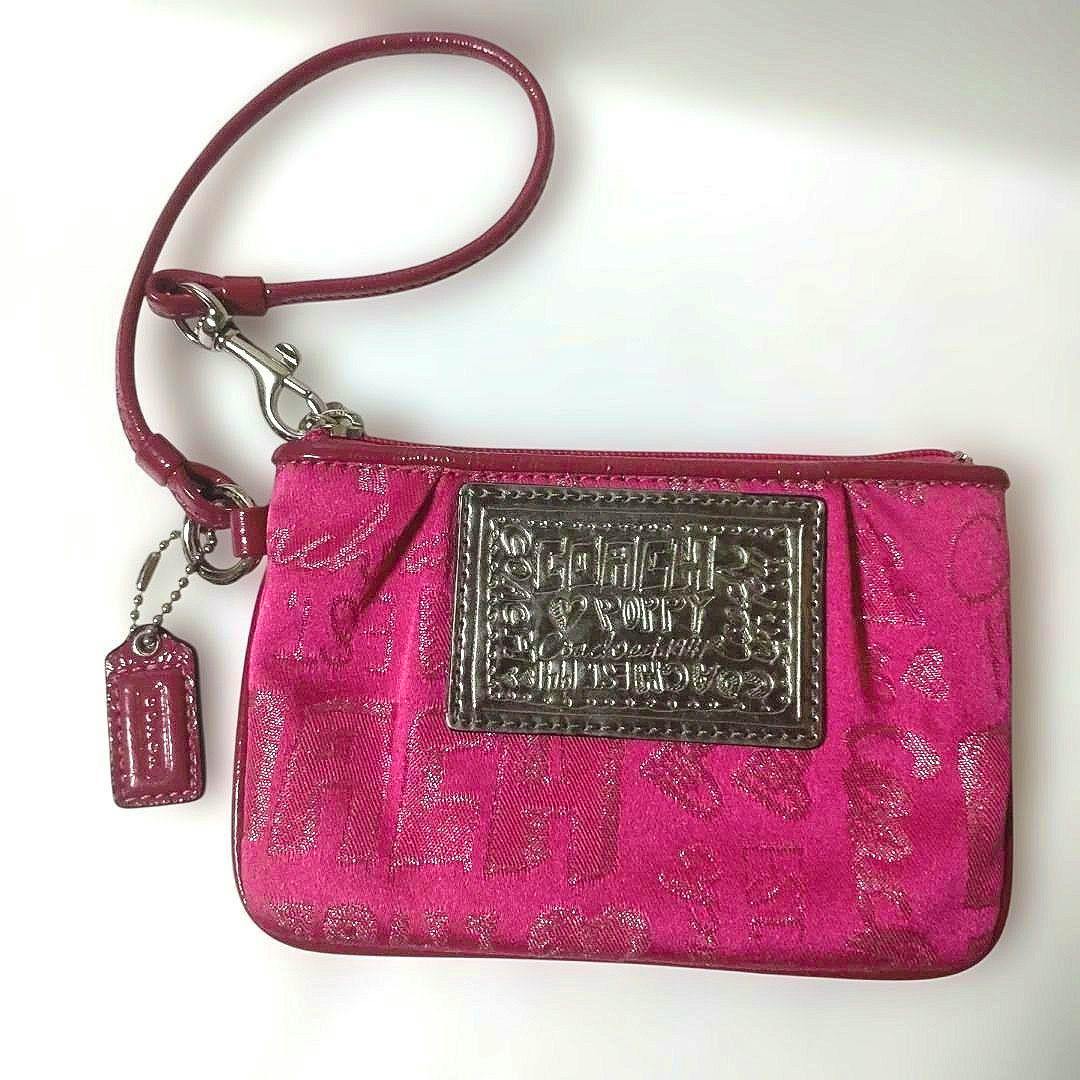 Pink Coach wristlet pouch with a leather wrist strap, Coach hangtag, and front logo patch.