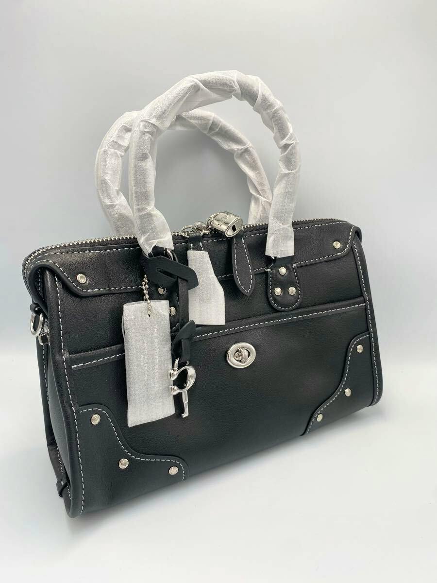Black leather Coach satchel bag with wrapped handles, silver hardware, and stitched detailing on a plain background.
