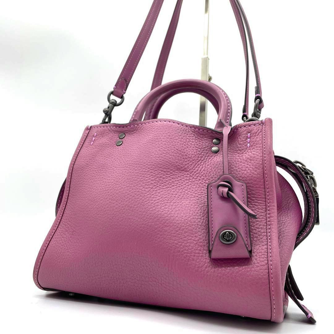 Rose-pink Coach Rogue 2way leather bag shown from the front-left on a white background.