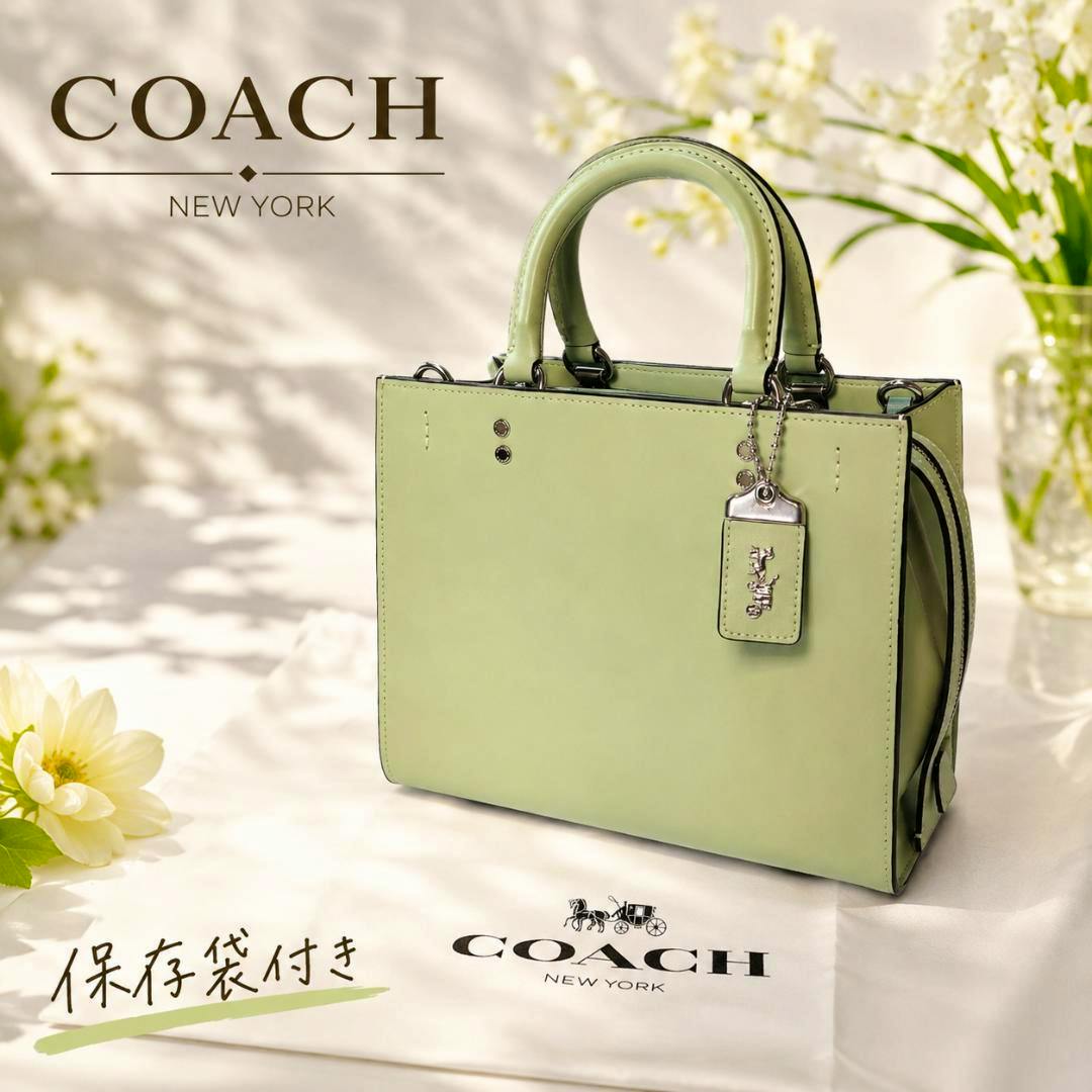 Green Coach Rogue 25 3-way leather handbag with top handles and hangtag displayed on a branded dust bag.