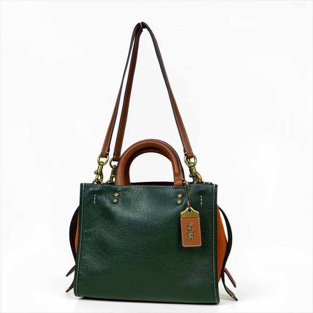 Front view of the Coach Rogue 25 2way color-block cow leather handbag in green with brown handles and strap.