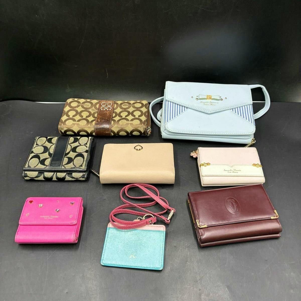 Eight assorted wallets and a small shoulder wallet arranged on a black surface.