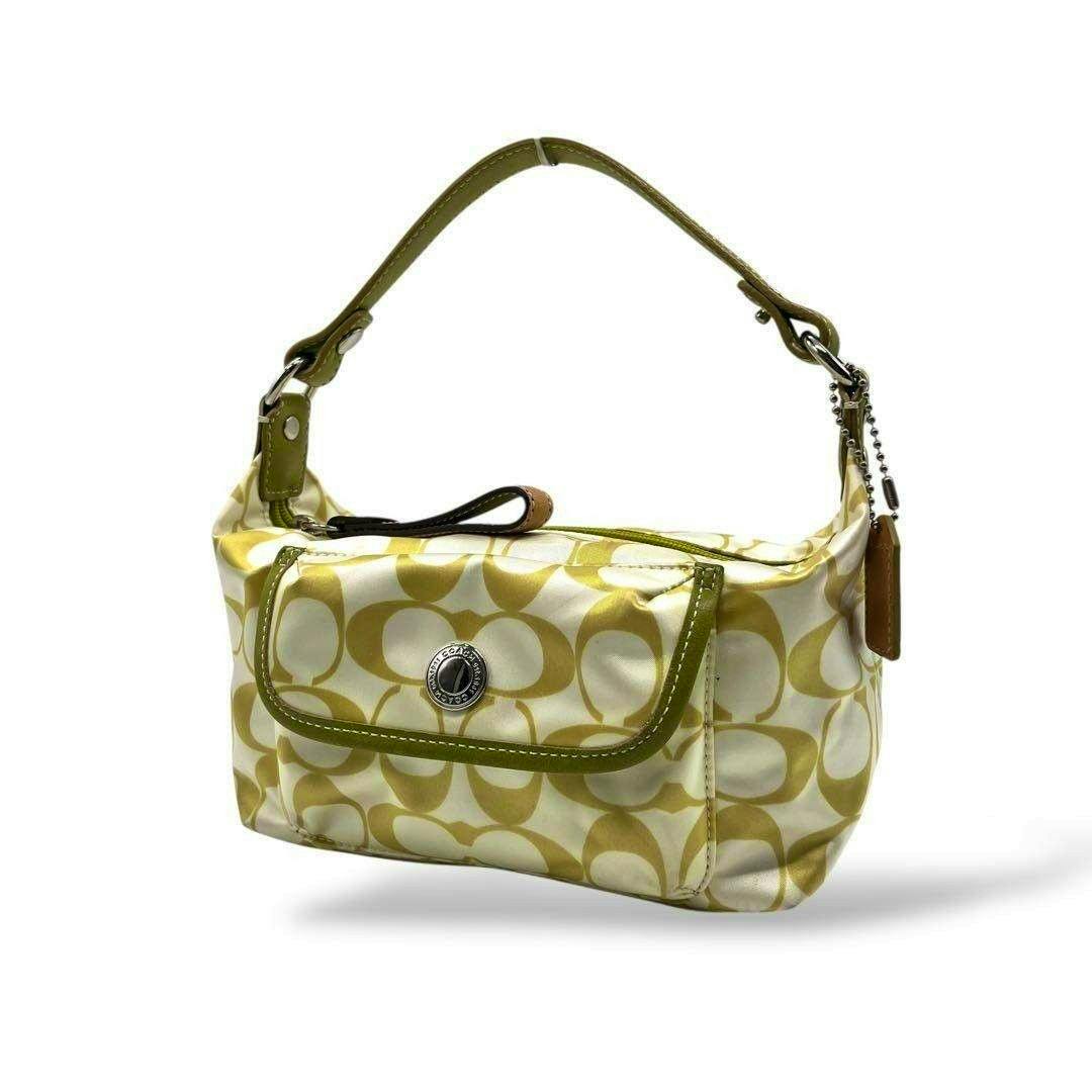 Khaki green Coach Scribble C mini canvas bag with short handle and front flap pocket on white background.