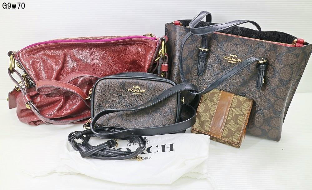 Photo of multiple COACH bags and a small COACH wallet arranged on a white surface.