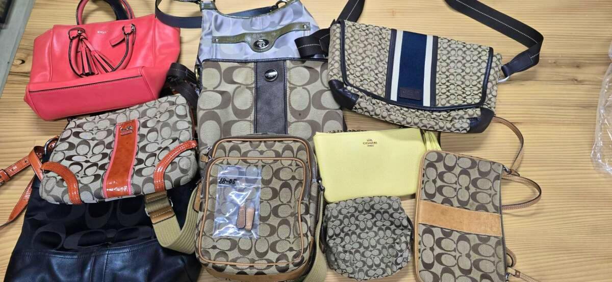 Top-down photo of a set of Coach shoulder bags and small accessories arranged on a wooden tabletop.