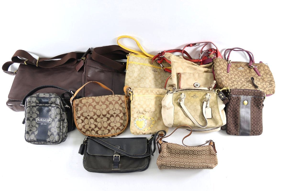 A collection of Coach shoulder, tote, and hand bags arranged on a white background.