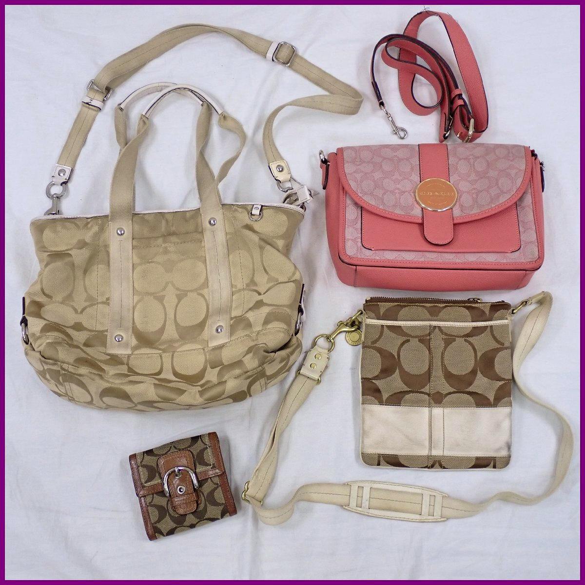 Four COACH signature pieces laid flat on a white background: a beige signature tote, a pink shoulder bag, a brown-and-cream signature crossbody, and a small signature wallet.
