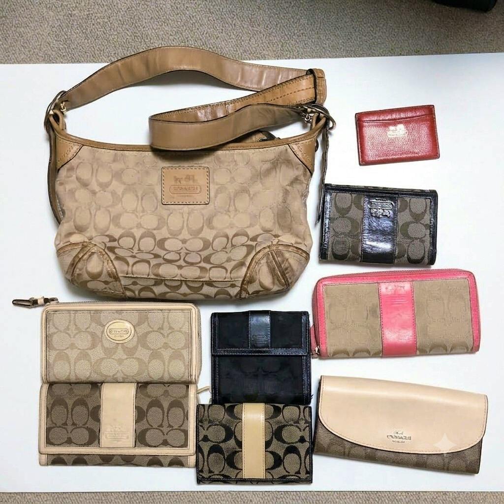 Nine Coach signature canvas items arranged on a white background, including a shoulder bag and various wallets and card cases.