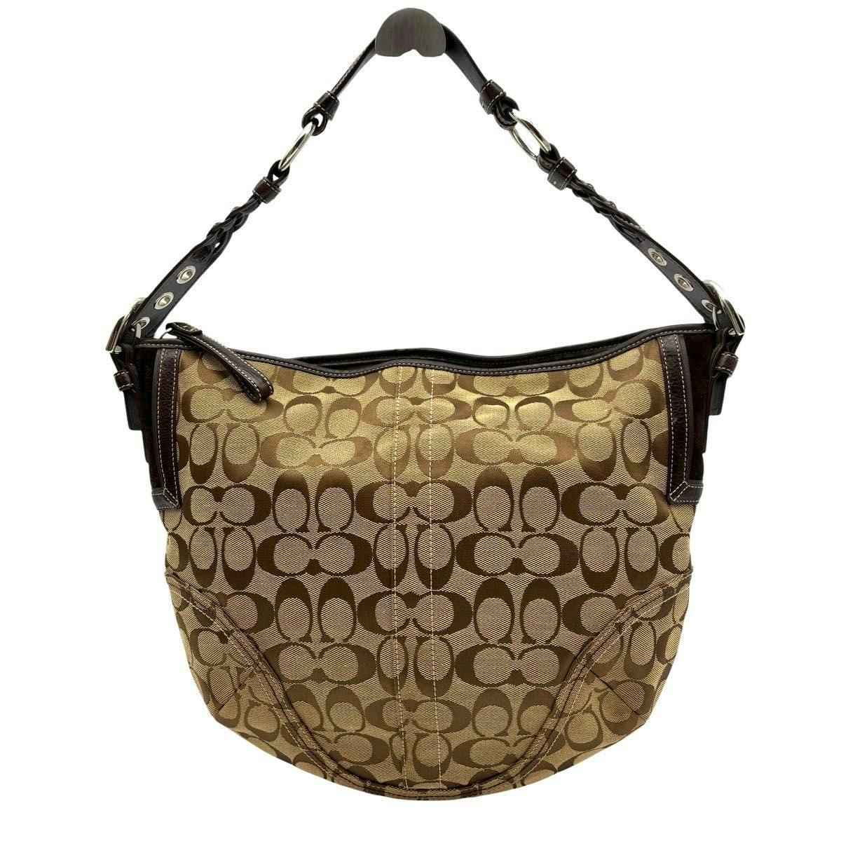 Front view of a brown COACH signature canvas and leather hobo shoulder bag with a single braided shoulder strap.