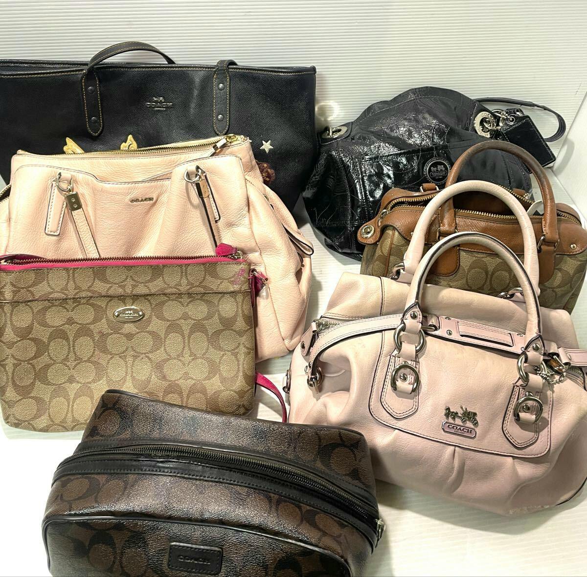 Several Coach shoulder bags, tote bags, and small handbags arranged together on a white surface.
