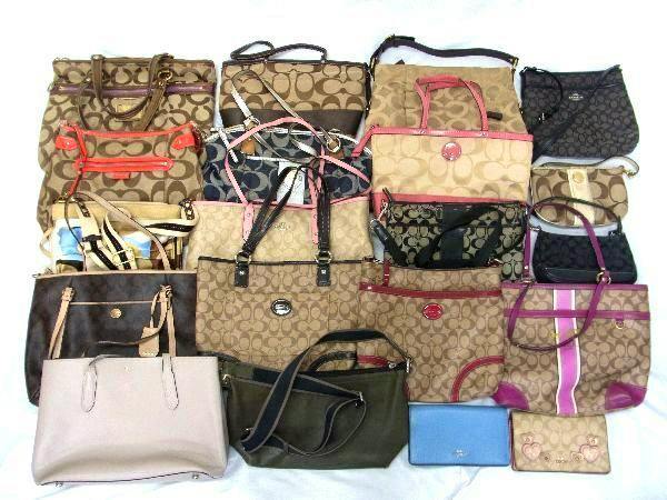 Multiple COACH signature canvas and leather tote bags, shoulder bags, and wallets arranged on a flat surface.
